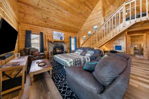 赛维尔维尔Serenity, A Rustic Log Cabin Retreat的带沙发和楼梯的客厅