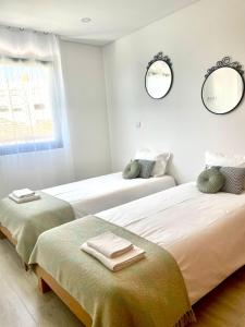 PerafitaPorto Smart Apartments Comfort的白色客房的两张床,配有两面镜子