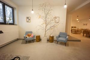 兹诺伊莫Penzion 7 pokojů的客厅配有两把椅子,墙上有一棵树