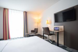 布拉河畔的海登海姆海登海姆品味酒店的酒店客房配有一张床、一张书桌和一台电视。