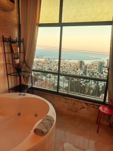 海法Amazing Panorama Bay view 3 room flat的带浴缸的浴室和大窗户