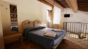 卡梅里诺Borgo de' Varano by Hotel I Duchi的一间卧室配有一张床,上面有两条毛巾