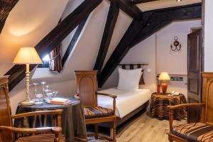 科尔马Hotel Restaurant Le Maréchal - Teritoria的卧室配有一张床和一张桌子及椅子