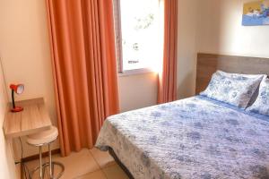 伊塔佩蒂宁加罗莎住宅公寓的一间卧室配有床、橙色窗帘和窗户