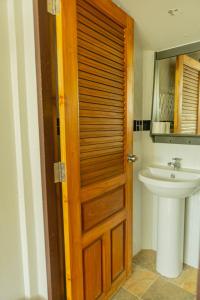 Ban Tao ThanApinya Resort Bangsarey的一间带木门和水槽的浴室