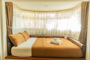 Ban Tao ThanApinya Resort Bangsarey的卧室内的一张床位,卧室的窗户上装有泰迪熊