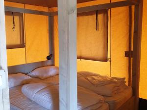 KesterenSafaritent Ranger Lodge的黄色墙壁的客房内设有两张双层床。