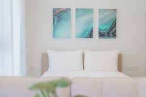 邦涛海滩Skypark Apartments by Laguna Phuket的卧室配有一张床,墙上挂有两幅画