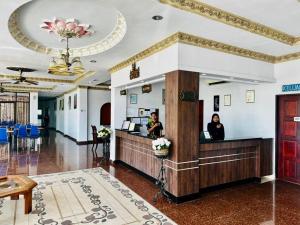 瓜埠Langkawi Baron Hotel - renovated 2023的坐在大堂前台的妇女