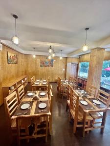 MirikAmaira Resort & Farms - Mirik, West Bengal的用餐室配有木桌和木椅