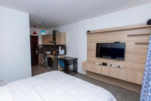 东勒贡OASIS PARK RESIDENCE的一间卧室配有一张床和一台平面电视