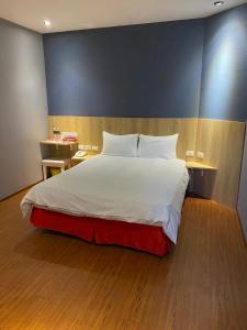 台南太子大饭店的一间卧室设有一张大床和蓝色的墙壁