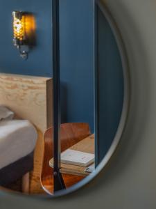 韦尼雪Eklo Lyon的镜子反射着一间房间,配有一张床和椅子