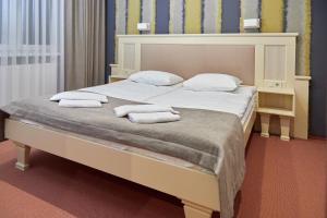 MostiskaHotel Korona的一间卧室配有一张大床和毛巾