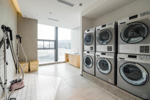 成都成都太古里未来中心亚朵酒店的洗衣房配有4台洗衣机和烘干机