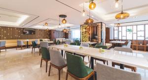 上海上海新国际博览中心龙阳路亚朵酒店的餐厅设有白色的桌子和绿色的椅子