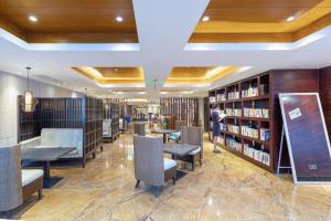 深圳深圳罗湖东门步行街亚朵X酒店的图书馆配有桌椅和书架