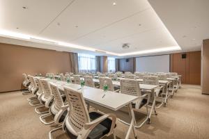 珠海珠海金湾机场亚朵酒店的一间会议室,配有白色的桌子和白色的椅子
