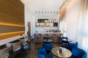 沃罗里尼The Quality Lodge - Self Check-in的一间设有蓝色椅子的餐厅和一间酒吧