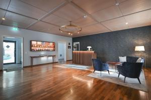 福森噶斯特豪斯圣乌尔里希酒店的客厅铺有木地板,配有桌椅。