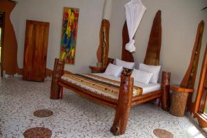 TanjiMama Africa Art Residence & Art Center Gambia的一间卧室,卧室内配有一张木床