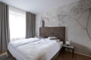 思科纳Mair Appartements in Schenna的一间卧室配有一张带白色床单的大床