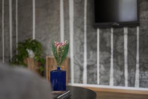 思科纳Mair Appartements in Schenna的花朵坐在桌子上的蓝色花瓶