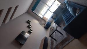 卡萨布兰卡Maarif的享有带桌子和蓝色沙发的客厅的顶部景色。