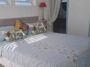 东方湾法国大街Tropical的卧室配有带枕头的白色床
