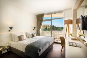 察夫塔特Remisens Hotel Albatros-All inclusive的酒店客房设有一张床和一个大窗户