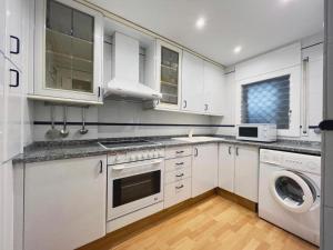 滨海圣波尔Hauzify I Apartament Can Reig的厨房配有白色橱柜、洗衣机和烘干机