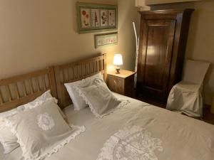 阿贝托内Baita Le Pozze的一间卧室配有一张带白色枕头和椅子的床