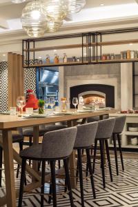 地拉那Tirana Marriott Hotel的带壁炉的用餐室配有桌椅