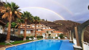 波多·纳奥斯穆拉雅公寓的棕榈树游泳池上的彩虹