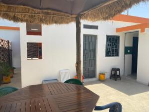 OuoranStudio neuf independant dans villa的庭院设有木桌和草伞。