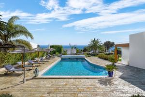 塞勒玛Romantik Villa的一个带椅子的庭院内的游泳池,以及大海