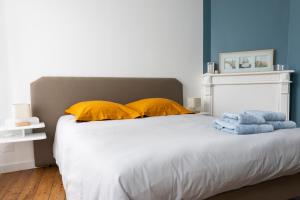 坎佩尔Appartement spacieux的一间卧室配有一张带黄色枕头和蓝色墙壁的床。