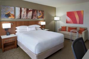 多伦多多伦多机场和会议中心万豪德尔塔酒店的卧室配有一张白色的大床和一张沙发。