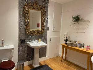 普拉姆斯特德Beautiful Traditional English 4 bedroom home in Greenwich的浴室设有水槽和墙上的镜子
