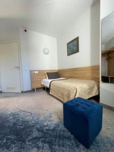 维尔纽斯Green Vilnius Hotel的一间卧室配有两张床和蓝色的搁脚凳