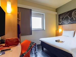 米兰宜必思米兰中心酒店的客房设有一张床、一张桌子和一把椅子。