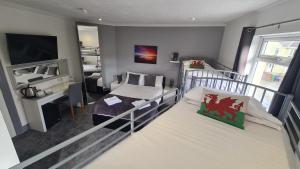 兰贝里斯Y Gwynedd Inn的一间卧室配有两张双层床和电视
