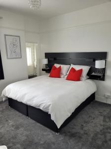 滨海绍森德Edelweiss Guest House的卧室配有带红色枕头的大型白色床