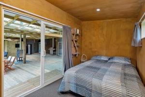 凯里凯里Waimate Farmstay - Kerikeri Holiday Home的一间卧室设有一张床和一个滑动玻璃门