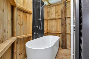 凯里凯里Waimate Farmstay - Kerikeri Holiday Home的浴室配有白色浴缸和木墙