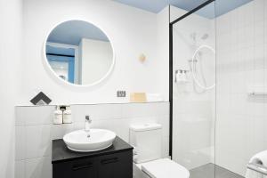 墨尔本Studio Apartments at Aurora near Melbourne Port的一间带水槽、卫生间和镜子的浴室