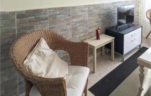 LadridoCasa El Rosedal的客厅配有带枕头的椅子和电视
