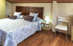 LadridoCasa El Rosedal的一间卧室配有一张带木制床头板和椅子的床。