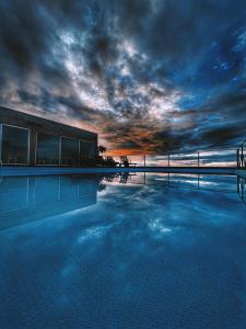 莫什泰鲁什Mosteiros Place的一座大型游泳池,上面有云天