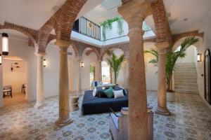 马贝拉La Fonda Heritage Hotel Luxury, Relais & Châteaux的一间带柱子和蓝色沙发的客厅